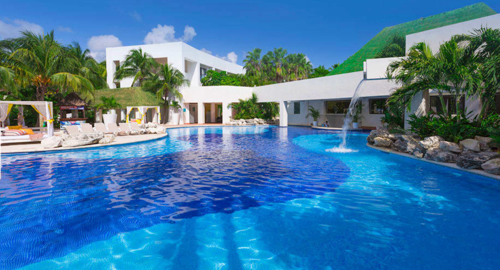 La piscine bleue et la verdure entourant l'h\u00f4tel Grand Oasis Tulum Riviera au Mexique.