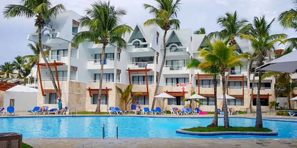 La piscine de l'h\u00f4tel Casa Marina Beach and Reef Resort, entour\u00e9e de palmiers en R\u00e9publique dominicaine.