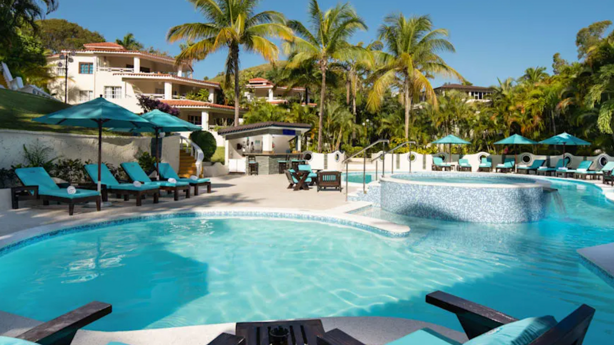 La piscine entourée de chaises longues et de palmiers de l'hôtel Lifestyle Residence Suites.
