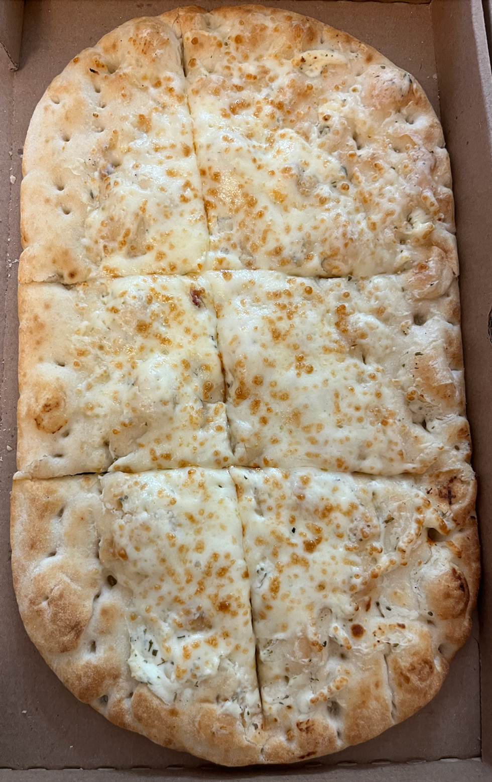 La pizza sur pain plat \u00e0 saveur Bacon plein-go\u00fbt du Tim Hortons dans sa bo\u00eete.