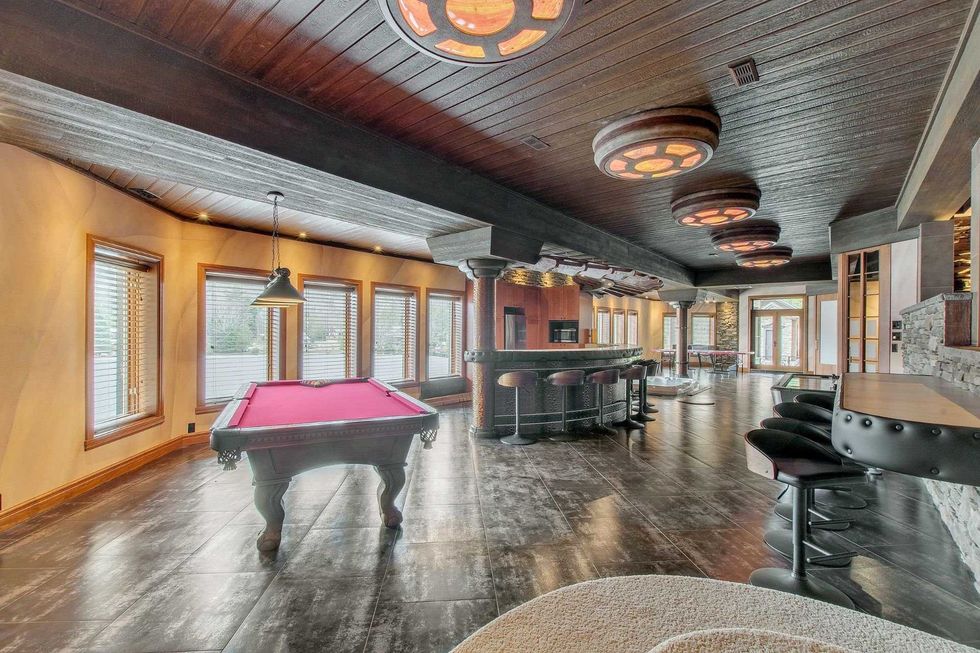 La salle de jeu avec table de billard, bar et d\u00e9tails m\u00e9di\u00e9vaux.