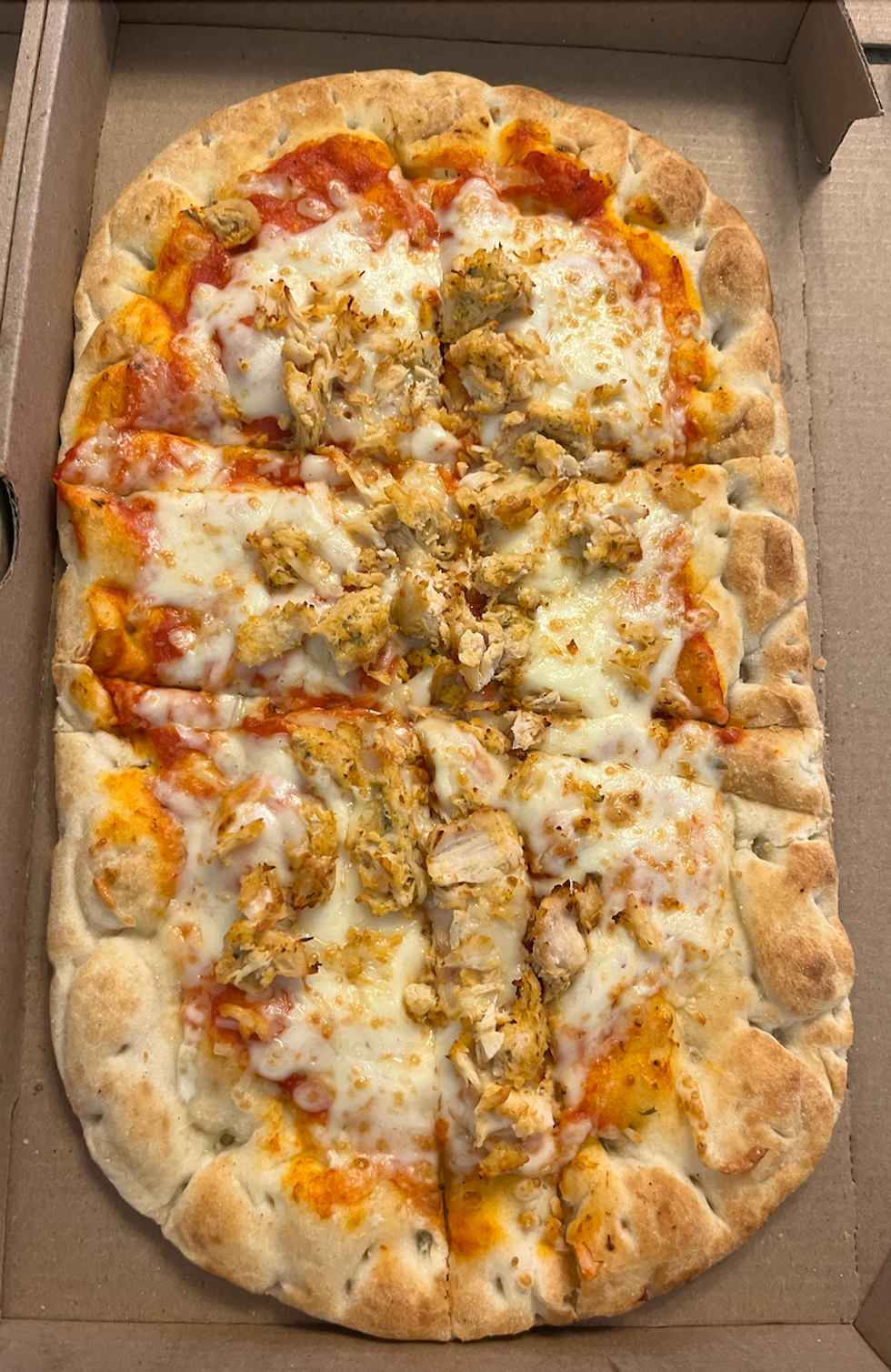 La \u200bpizza sur pain plat \u00e0 saveur Poulet Parmesan du Tim Hortons dans sa bo\u00eete.