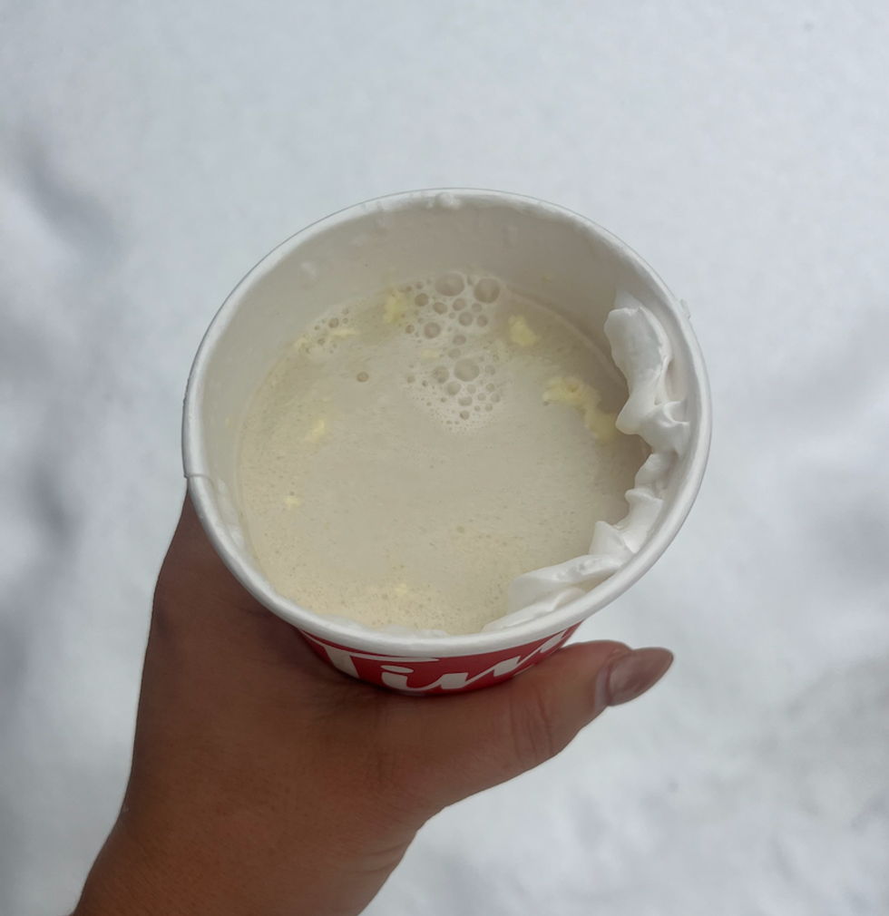 Le chocolat chaud au chocolat blanc et pistache du Tim Hortons dans une main \u00e0 l'ext\u00e9rieur.