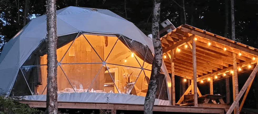 Le D\u00f4me La Hutte avec sa terrasse illumin\u00e9e \u00e0 Brownsburg au Qu\u00e9bec.