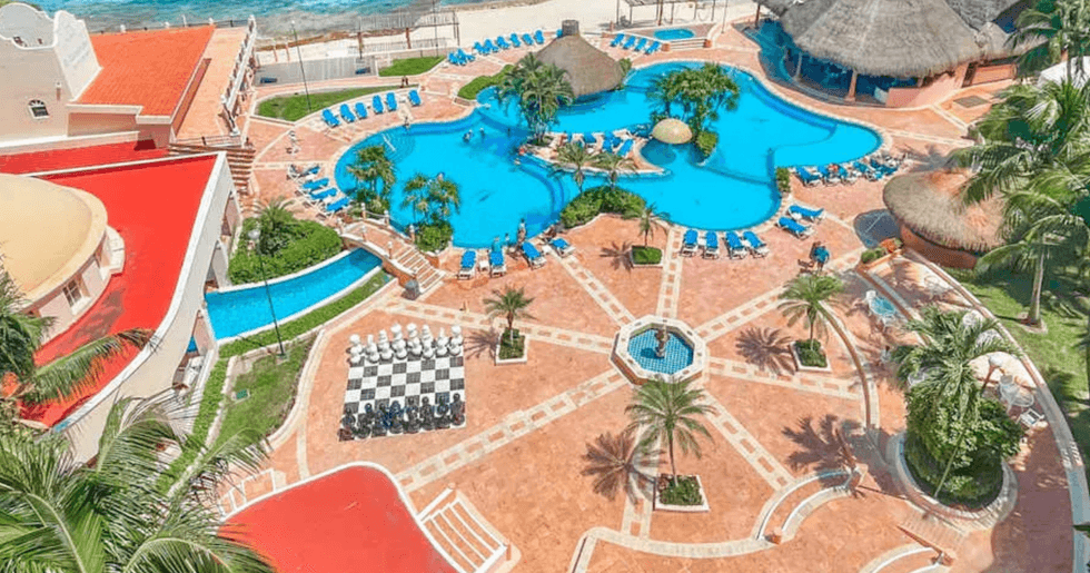 Le El Cozumeleno Beach Resort au Mexique avec sa piscine et ses palmiers en bord de mer.