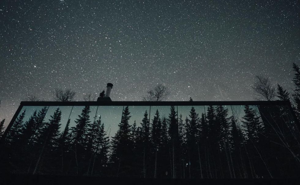 Le reflet des arbres sur la fa\u00e7ade du chalet.