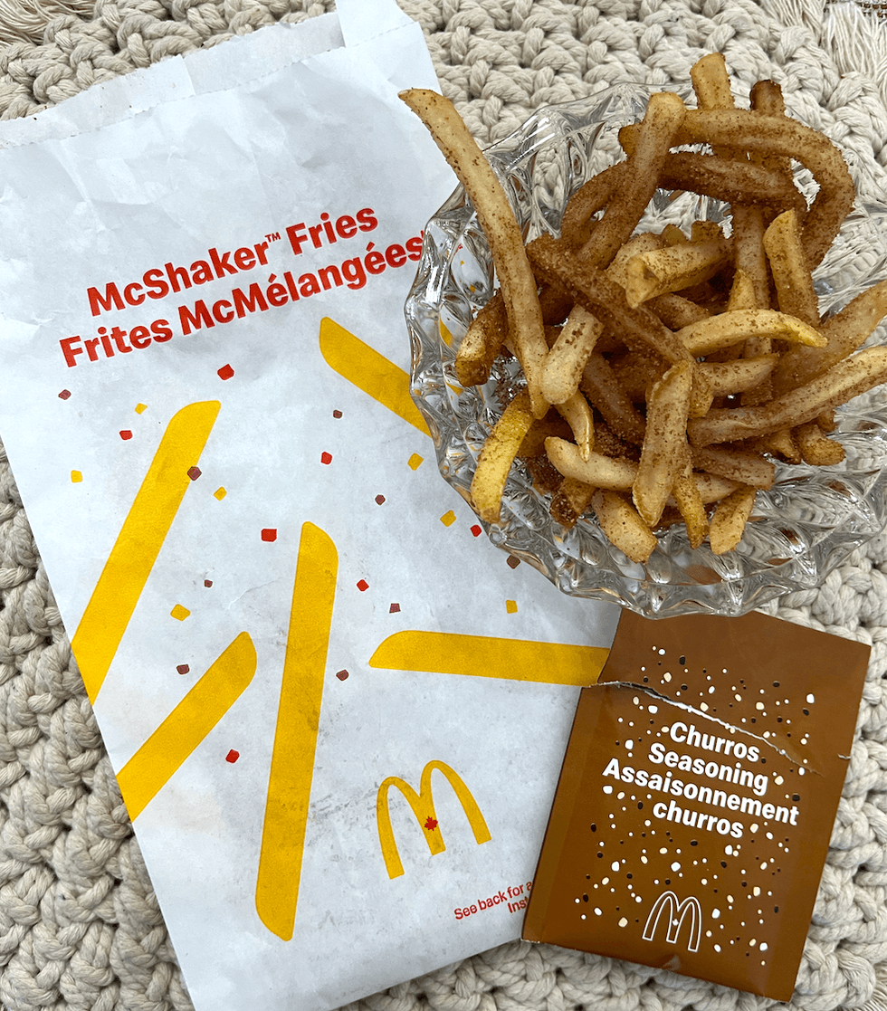 Le sac pour m\u00e9langer les frites, le sachet d'assaisonnement Churros, ainsi que les frites assaisonn\u00e9es.