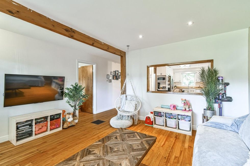 Le salon aux murs blancs d'une maison de plain-pied \u00e0 vendre \u00e0 Saint-Eustache.