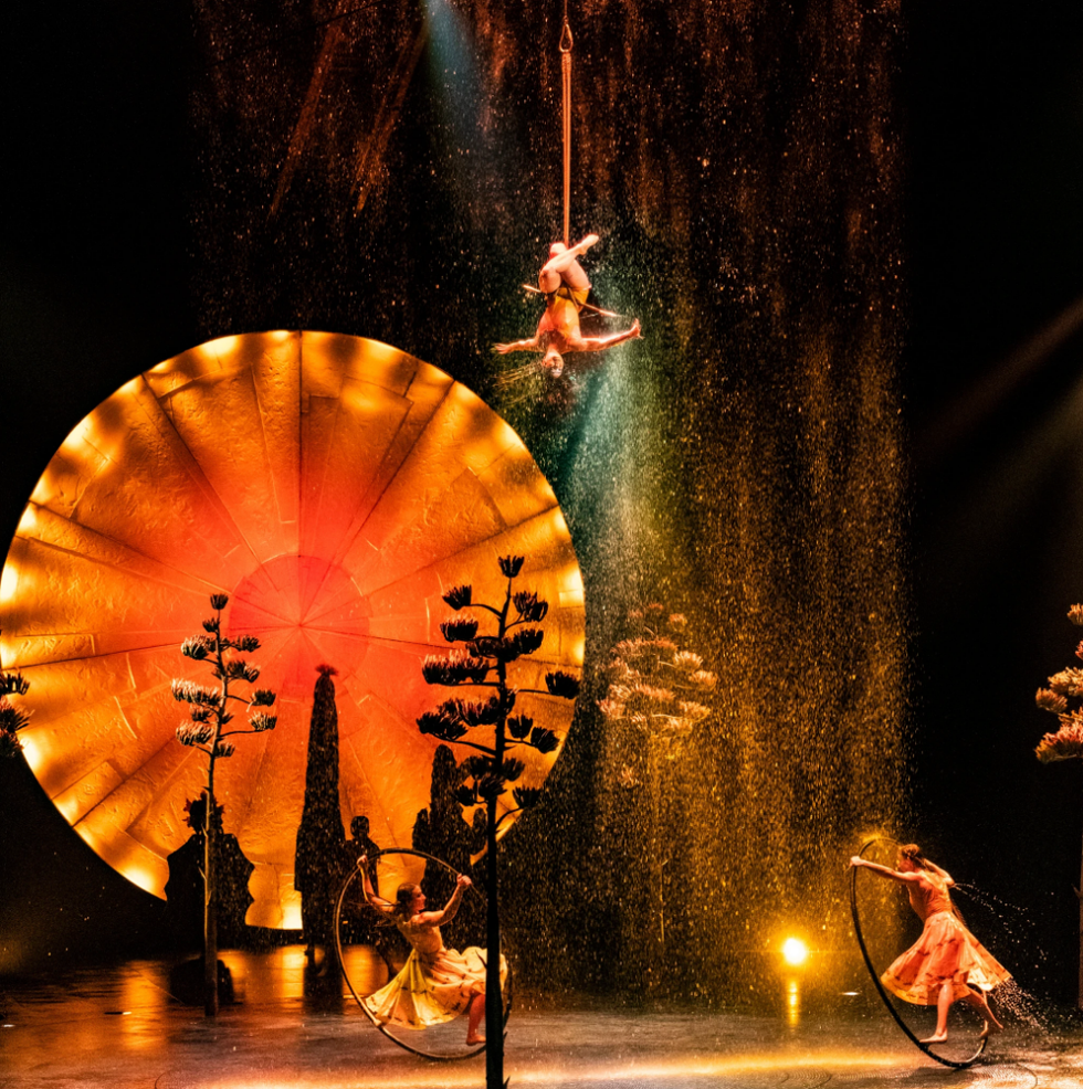 Le spectacle Luzia du Cirque du Soleil, avec une trap\u00e9ziste et des acrobates de roue Cyr \u00e0 travers une chute d'eau.