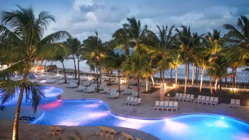 Le Viva Tangerine By Wyndham, avec sa grande piscine et ses b\u00e2timents lumineux entour\u00e9s de palmiers.