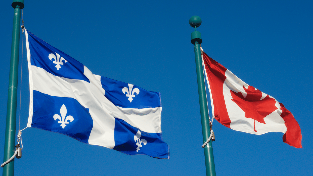 Les drapeaux du Québec et du Canada qui flottent au vent.
