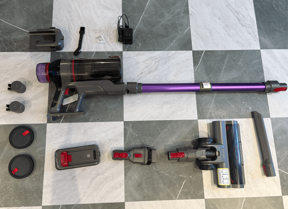 Les parties s\u00e9par\u00e9e de l'aspirateur-balai sans fil MQDXE sur un plancher.