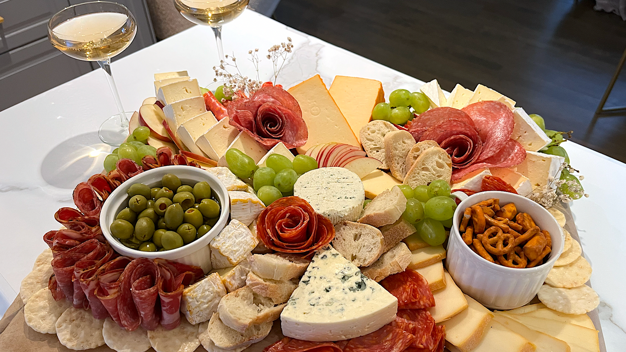 Luxueux plateau de fromages et charcuteries avec cinq fromages et trois viandes différentes.