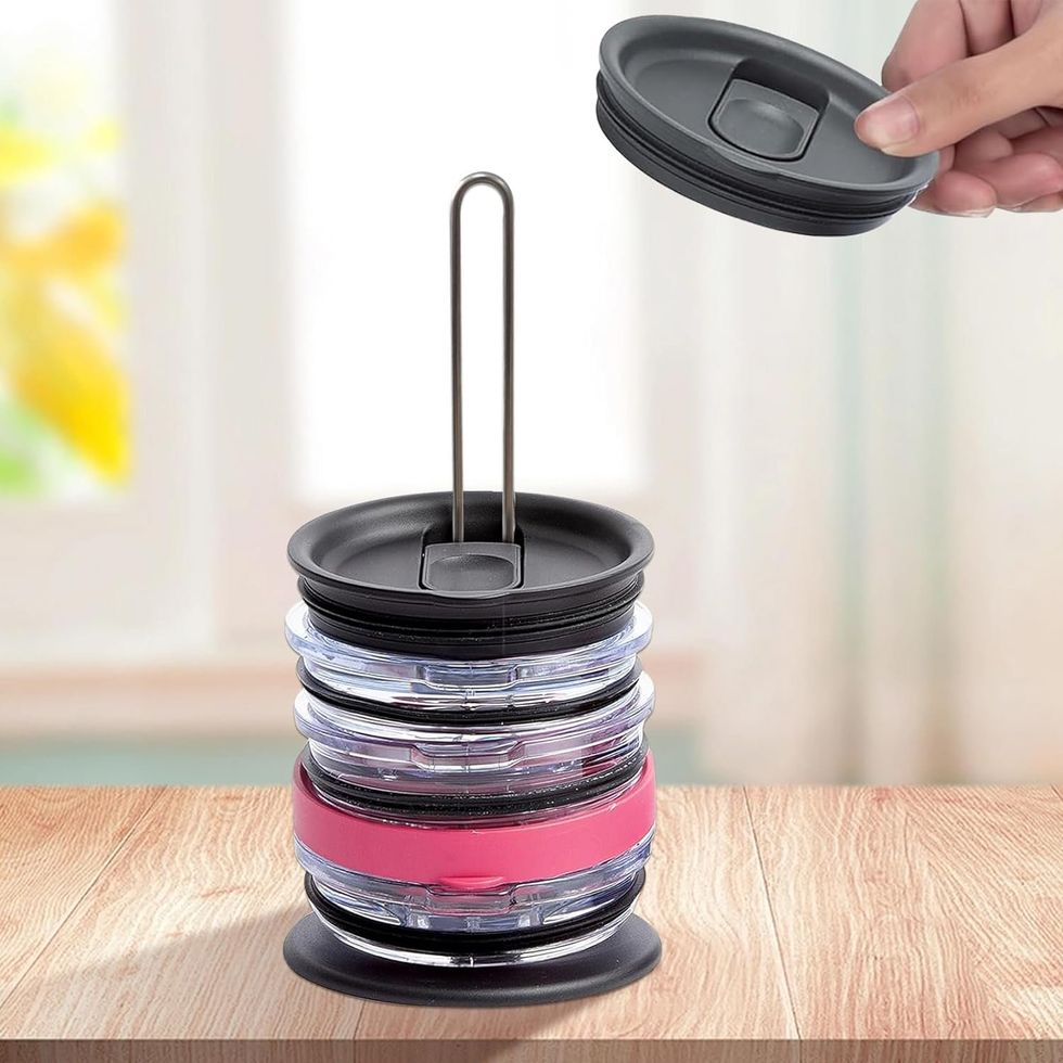 Main posant un couvercle de gobelet sur un support noir et en m\u00e9tal.