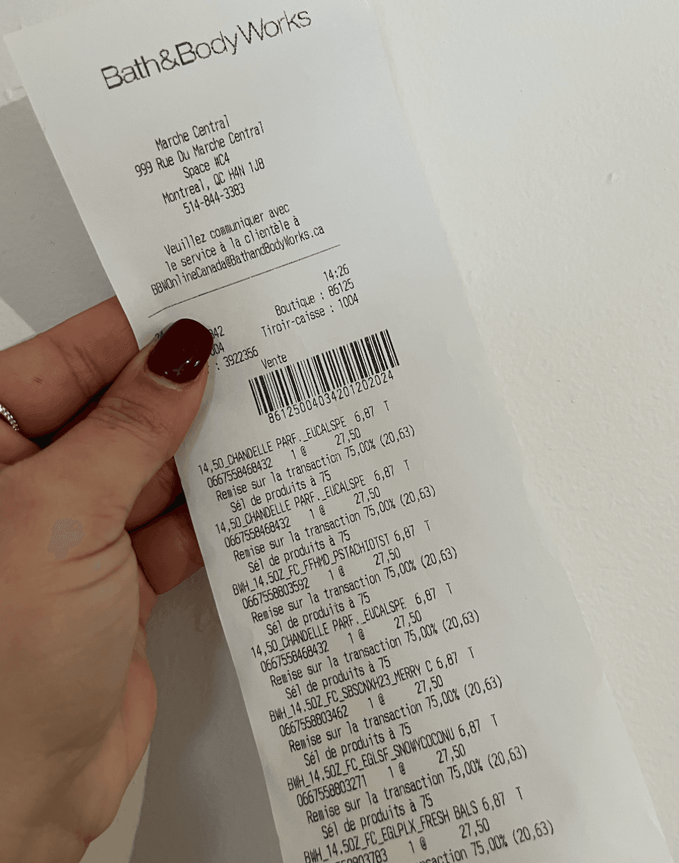 Main qui tient une facture du Bath & Body Works.