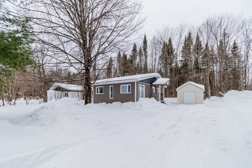 Maison de plain-pied de couleur taupe vue de c\u00f4t\u00e9 en hiver, \u00e0 vendre au Qu\u00e9bec.