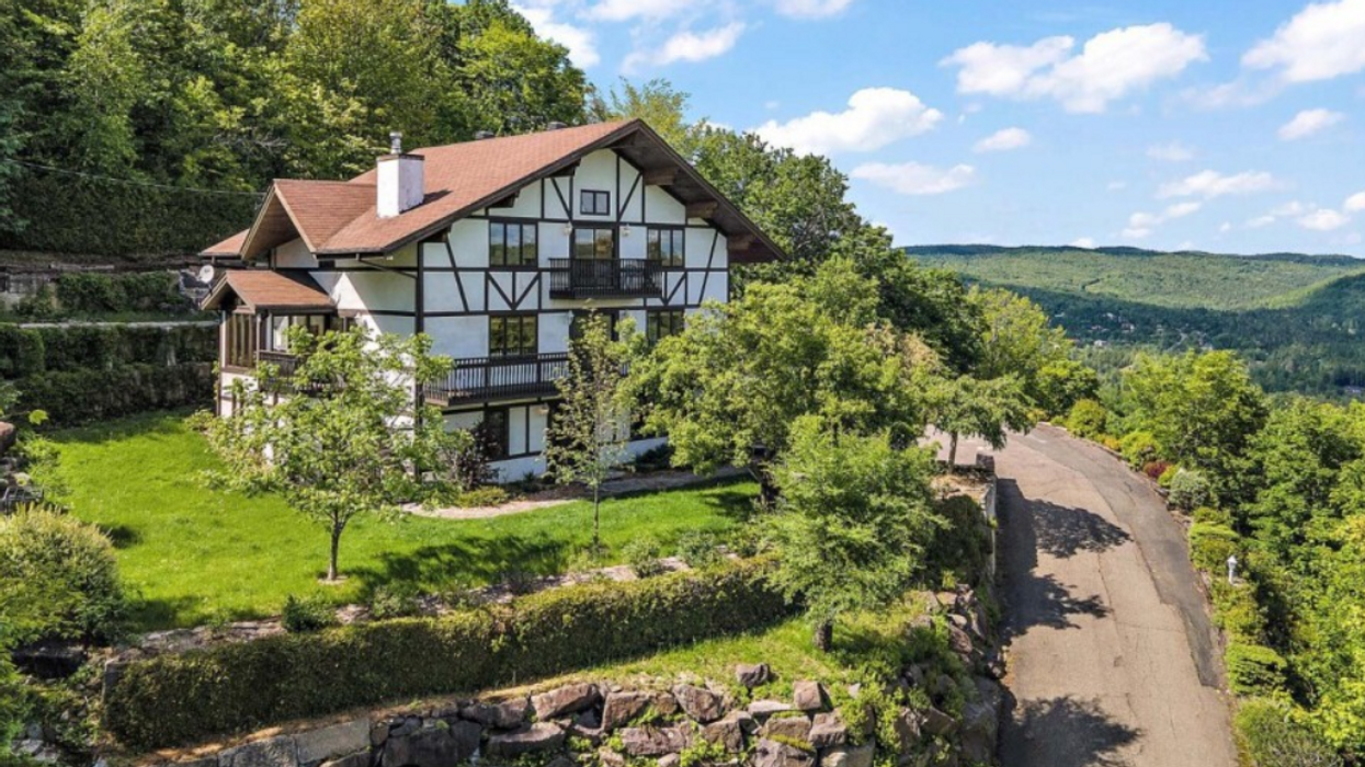 Maison de style chalet suisse sur une montagne.