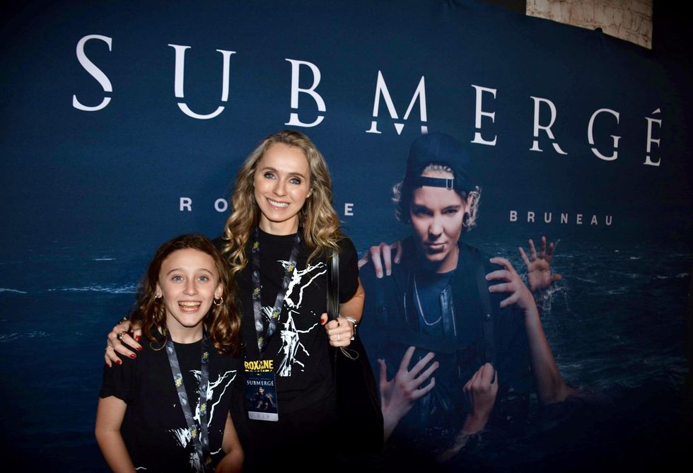 Marie-Andr\u00e9e Poulin et sa fille qui posent devant l'affiche de Submerg\u00e9.