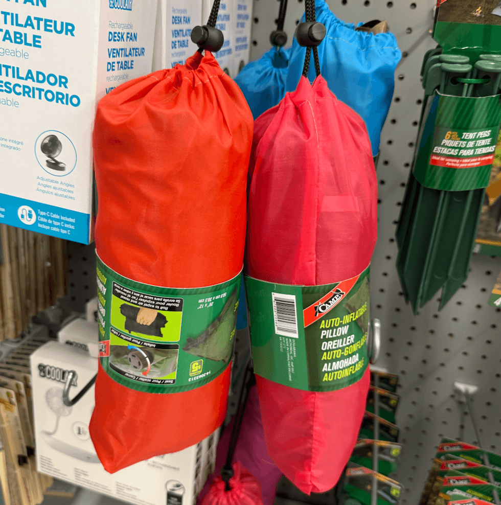 Oreillers auto-gonflables de diff\u00e9rentes couleurs suspendus dans une all\u00e9e de Dollarama.