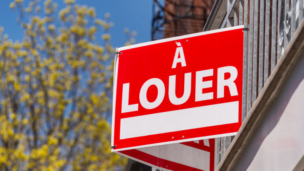 Pancarte à louer accrochée sur le balcon d'un immeuble à Montréal.
