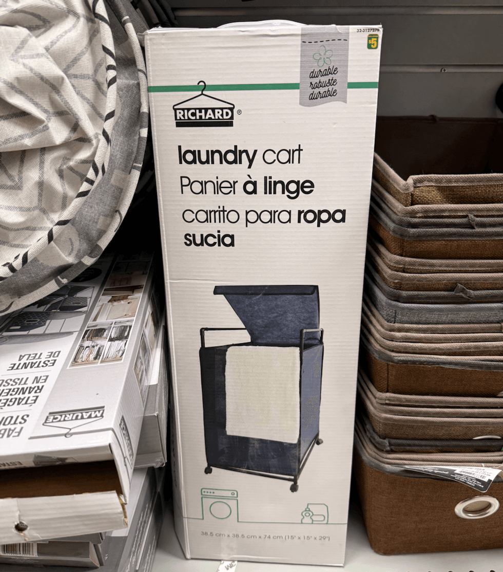 Panier \u00e0 linge gris fonc\u00e9 sur structure noire avec couvercle et roulettes.