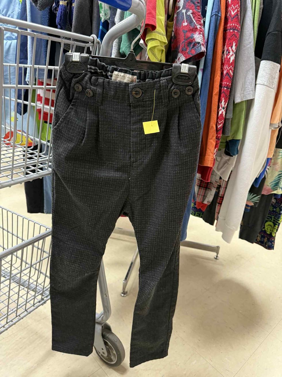 Pantalons carreaut\u00e9s dans la section liquidation pour enfants de la friperie Au Grenier Populaire.