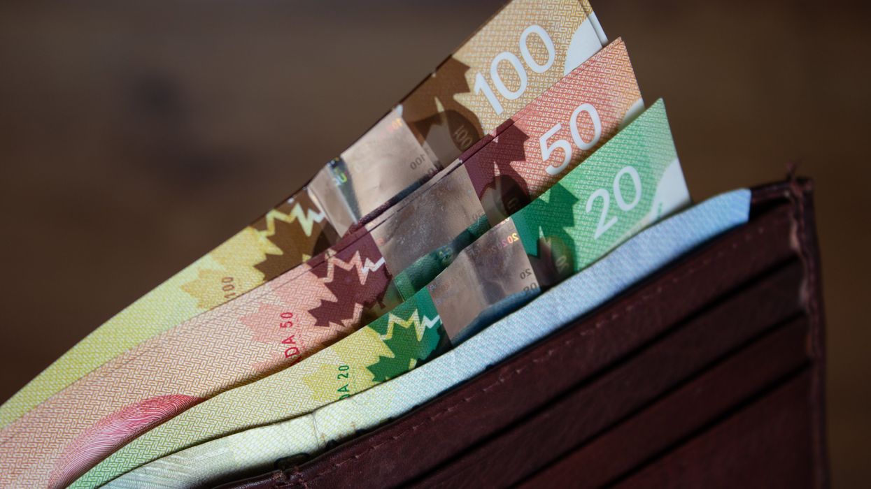 Photo de billets de banque canadiens sortant d'un portefeuille.
