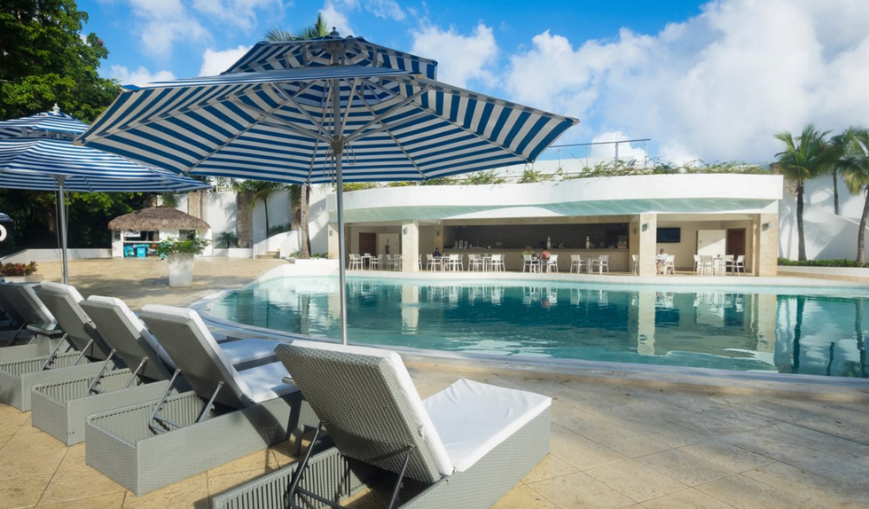 Piscine principale avec vue sur le bar de l'h\u00f4tel Viva Heavens by Wyndham \u00e0 Puerto Plata en R\u00e9publique dominicaine.