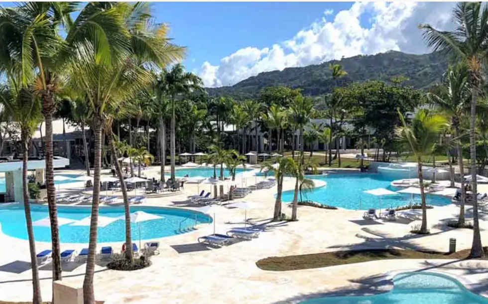 Piscines entour\u00e9es de palmiers au Senator Puerto Plata Hotel en R\u00e9publique dominicaine.