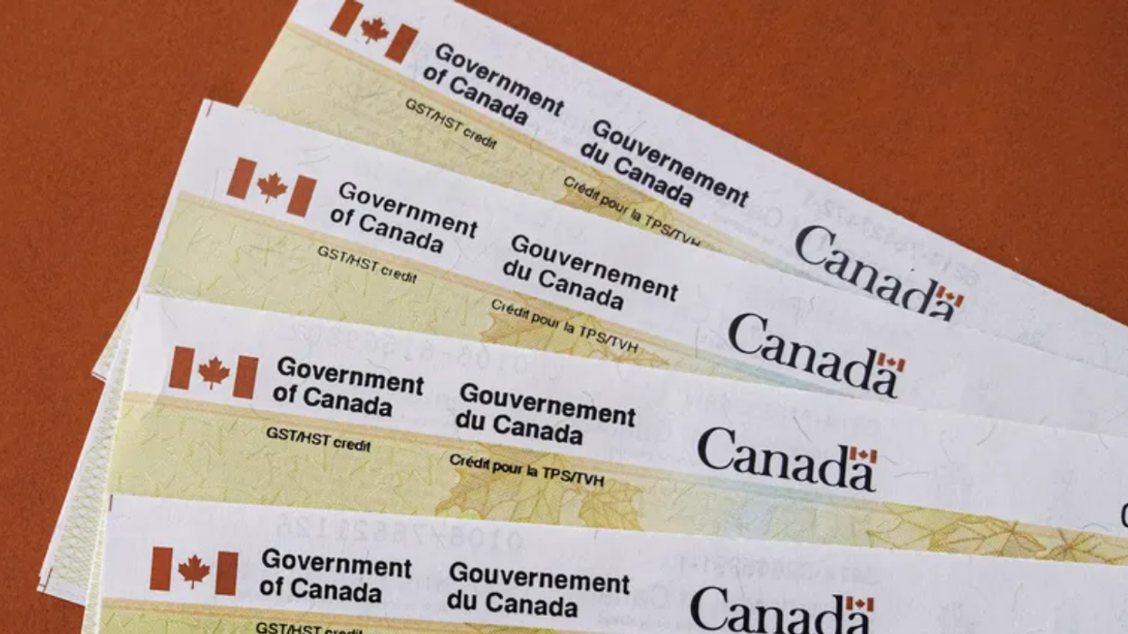 Plusieurs chèques du gouvernement de l'agence de revenu du Canada sont étalés sur une table.