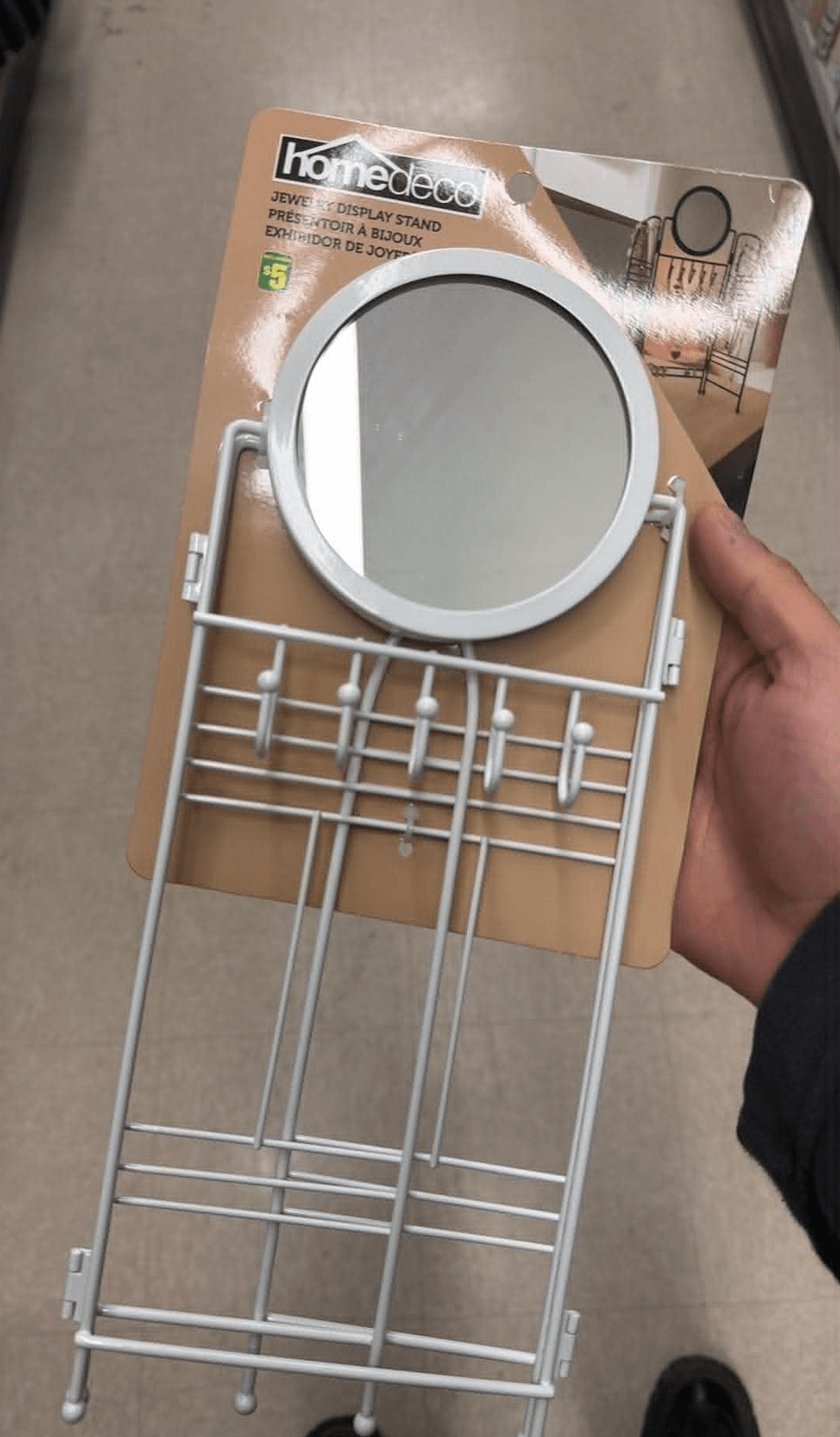 Pr\u00e9sentoir \u00e0 bijoux avec miroir dans une main au Dollarama.
