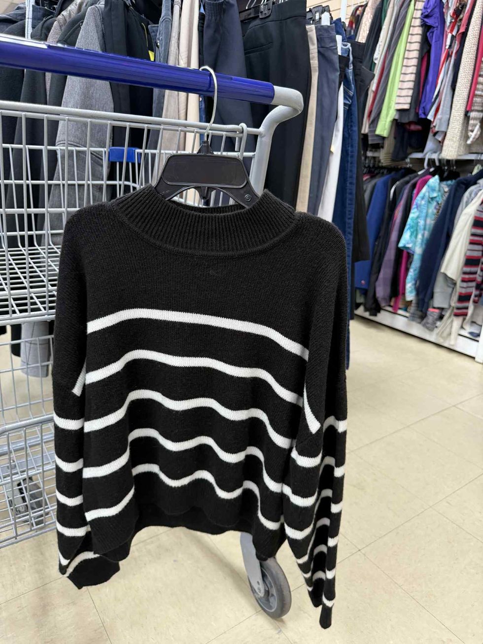 Pull en lainage lign\u00e9 noir et blanc dans la section liquidation pour adultes de la friperie Au Grenier Populaire.