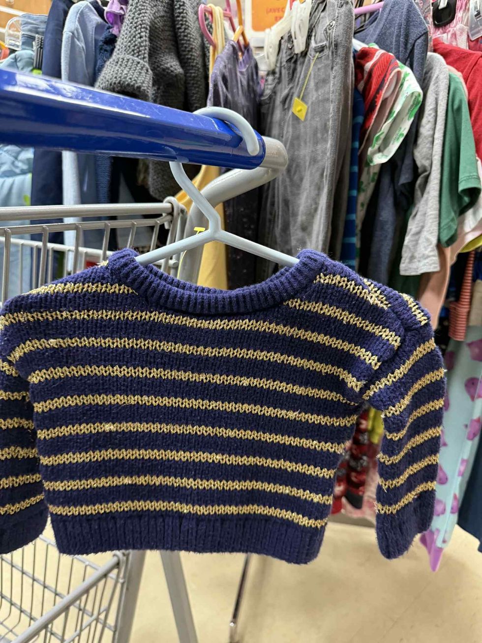 Pull en laine bleu marine et jaune dans la section liquidation pour enfants de la friperie Au Grenier Populaire.