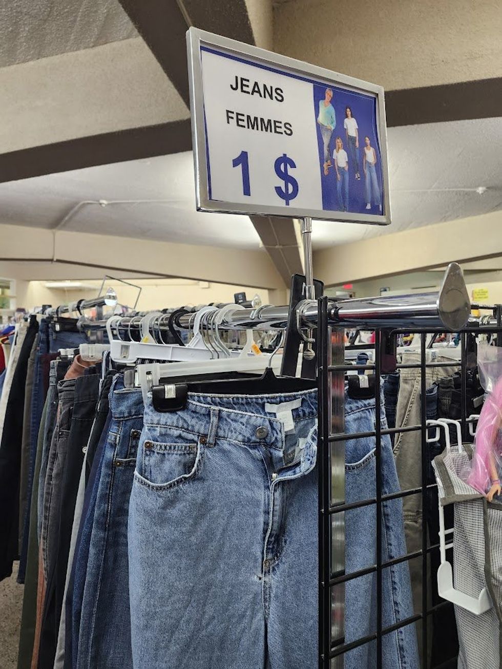 Rack de jeans avec affiche du prix de 1$ par paire de jeans.