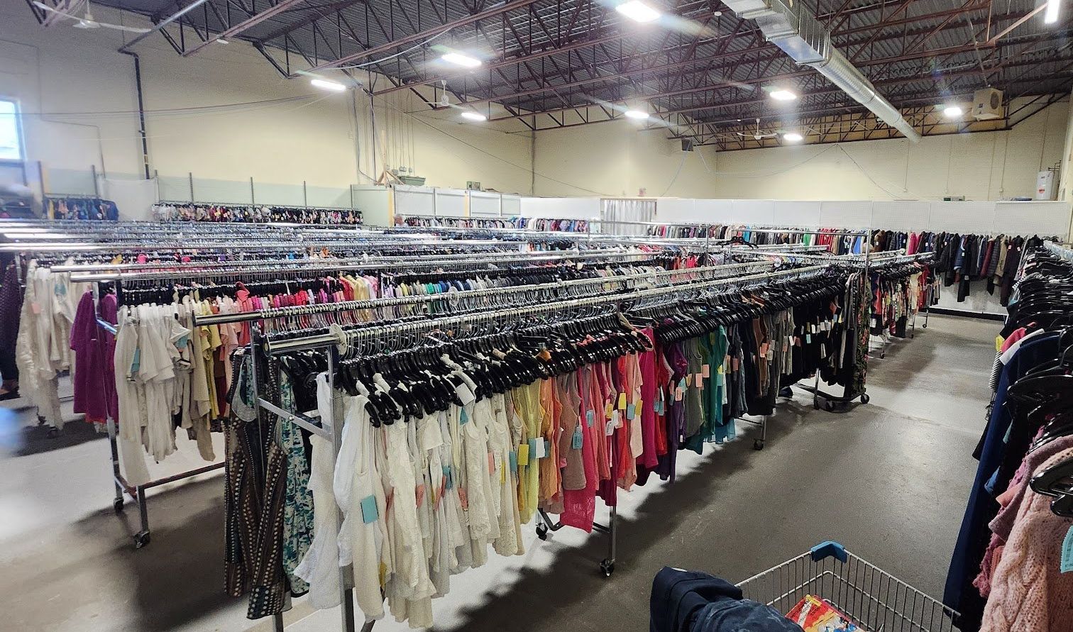 Rang\u00e9es de v\u00eatements dans une friperie.