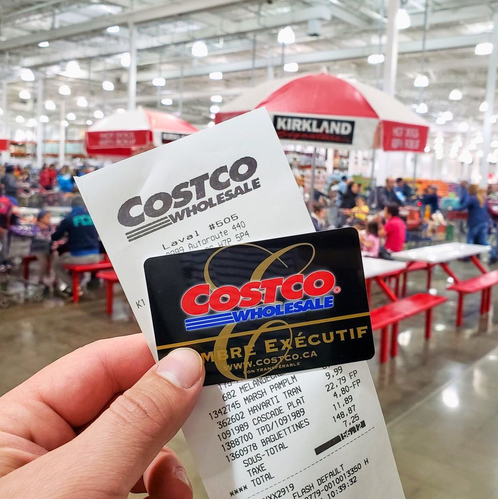 Re\u00e7u Costco et carte de membre ex\u00e9cutif avec en arri\u00e8re-plan la succursale de Laval.