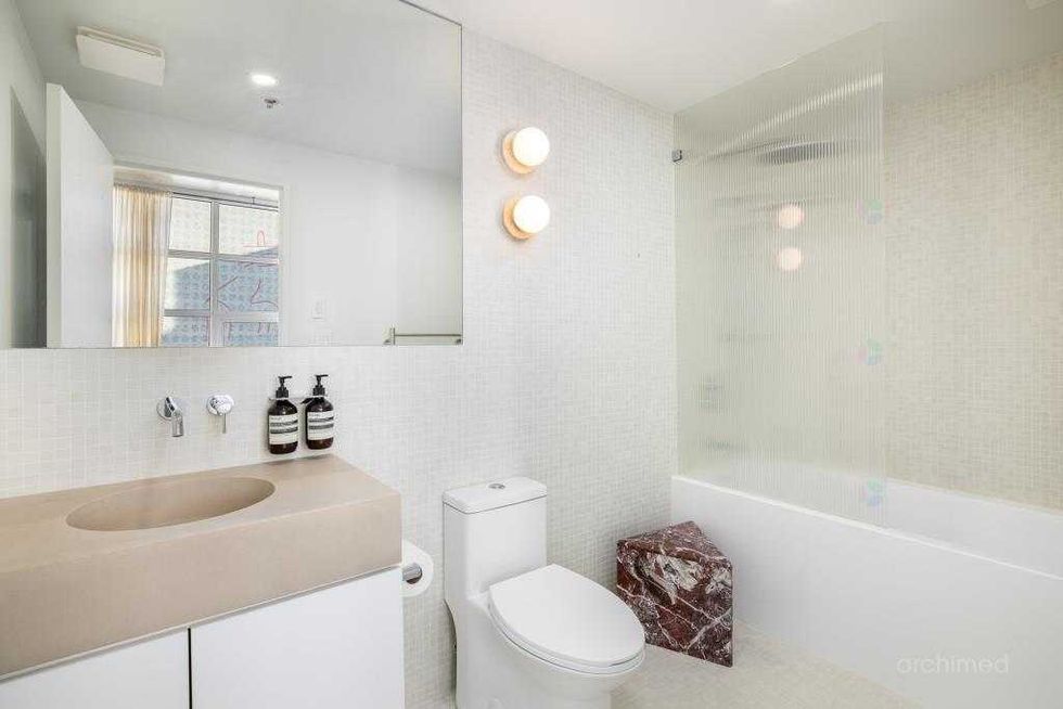 Salle de bain moderne et \u00e9pur\u00e9e avec baignoire, finitions haut de gamme et \u00e9clairage doux au design contemporain.