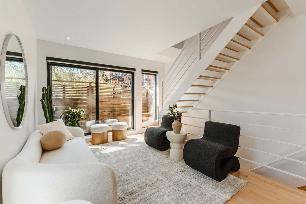 Salon moderne avec grandes portes vitr\u00e9es donnant sur la cour arri\u00e8re.