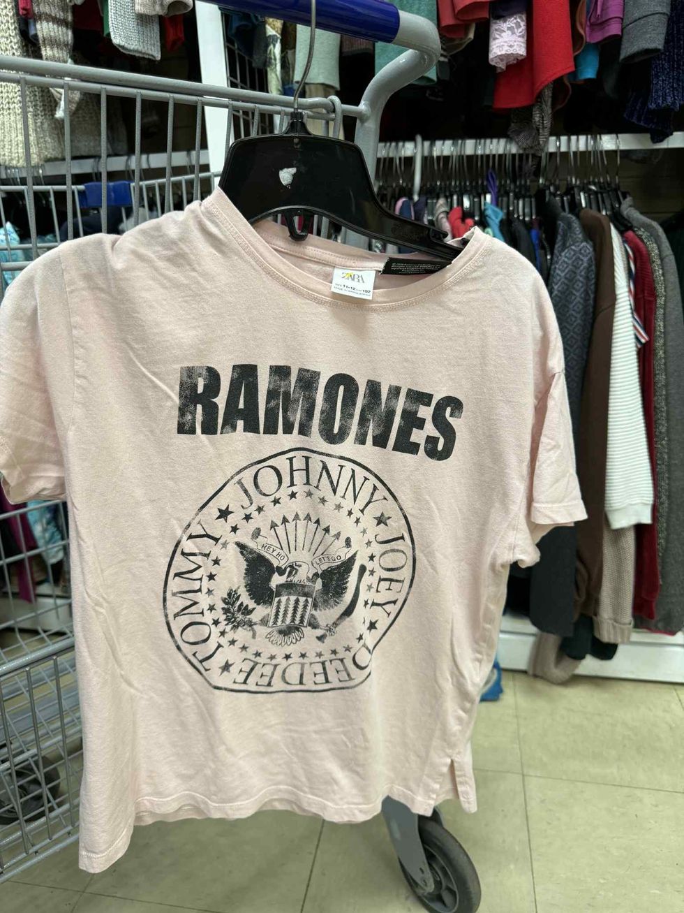 T-shirt beige du groupe The Ramones dans la section liquidation pour enfants de la friperie Au Grenier Populaire.