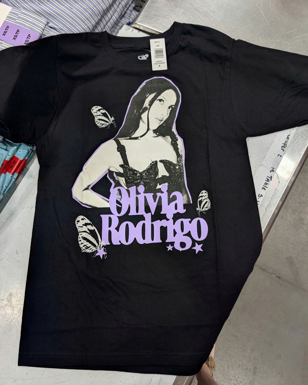 T-shirt noir avec imprim\u00e9 blanc et violet d'Olivia Rodrigo vendu dans le rayon mode chez Costco.