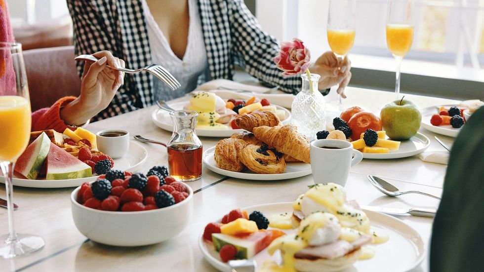 Table avec plusieurs assiettes contenant des plats typiquement servis au d\u00e9jeuner.