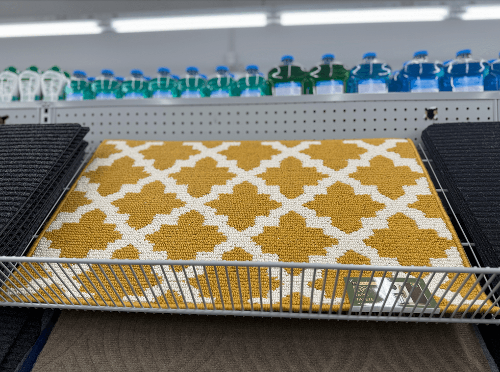 Tapis rectangulaire jaune moutarde \u00e0 motif g\u00e9om\u00e9trique blanc.