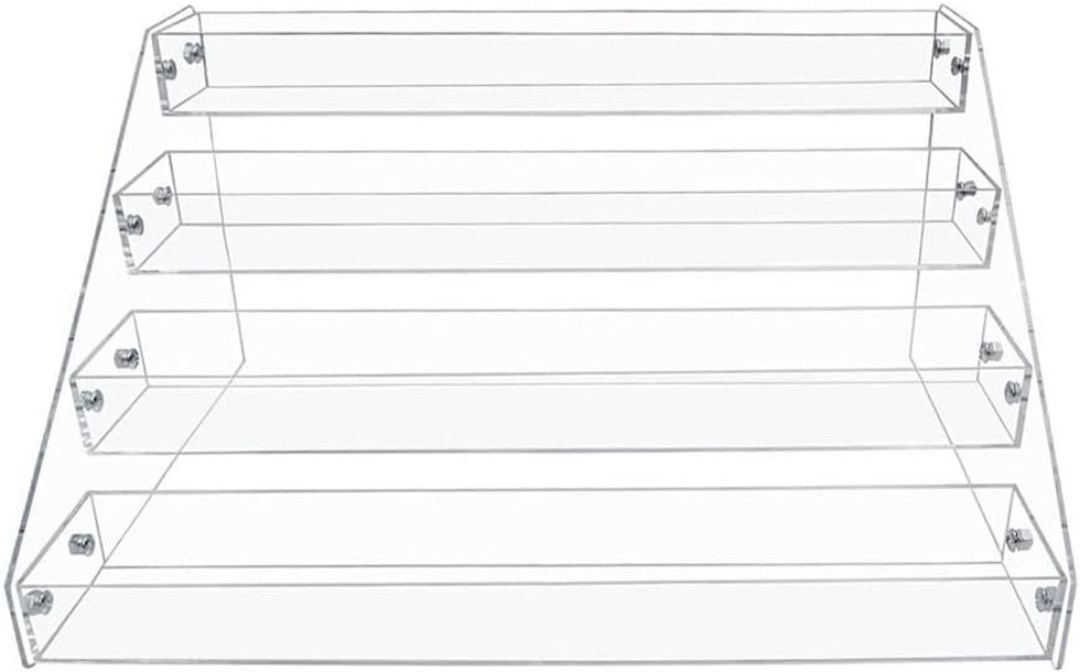 \u00c9tag\u00e8re \u00e0 quatre niveau en acrylique transparent, sur fond blanc.