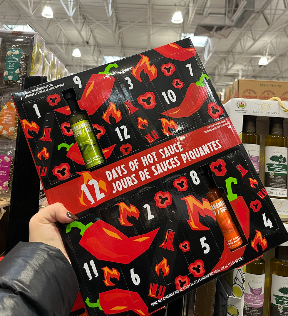 \u200bCalendrier de l'avent rouge et noir avec des illustrations de piments forts \u00ab 12 jours de sauce piquantes \u00bb.