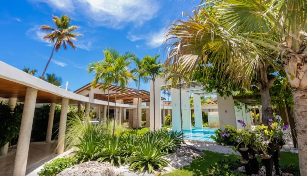 \u200bUne piscine entour\u00e9e de chaises longues et de v\u00e9g\u00e9tation \u00e0 l'h\u00f4tel Vista Sol Punta Cana en R\u00e9publique dominicaine.