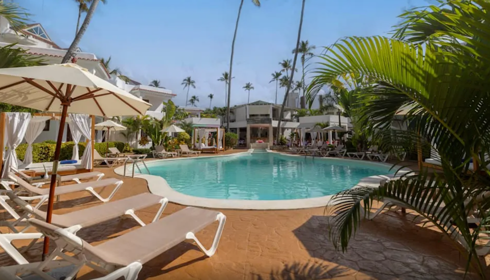 \u200bUne piscine entour\u00e9e de chaises longues et de v\u00e9g\u00e9tation \u00e0 l'h\u00f4tel Whala Bavaro en R\u00e9publique dominicaine.