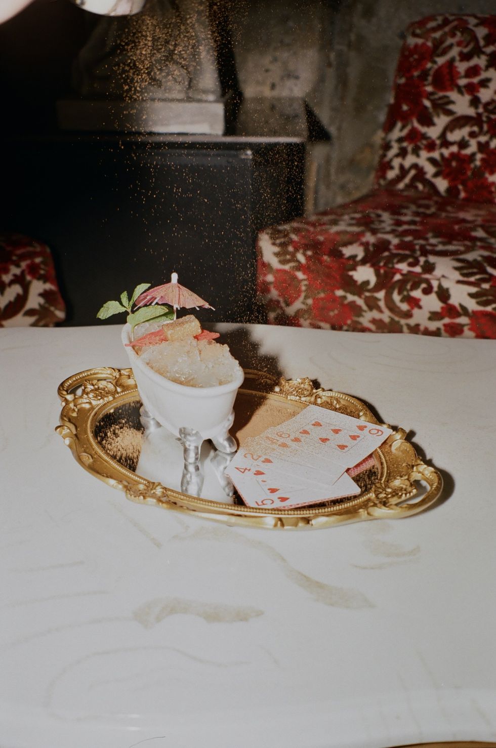 Un cocktail servi dans un verre en forme de bain sur un plateau dor\u00e9.