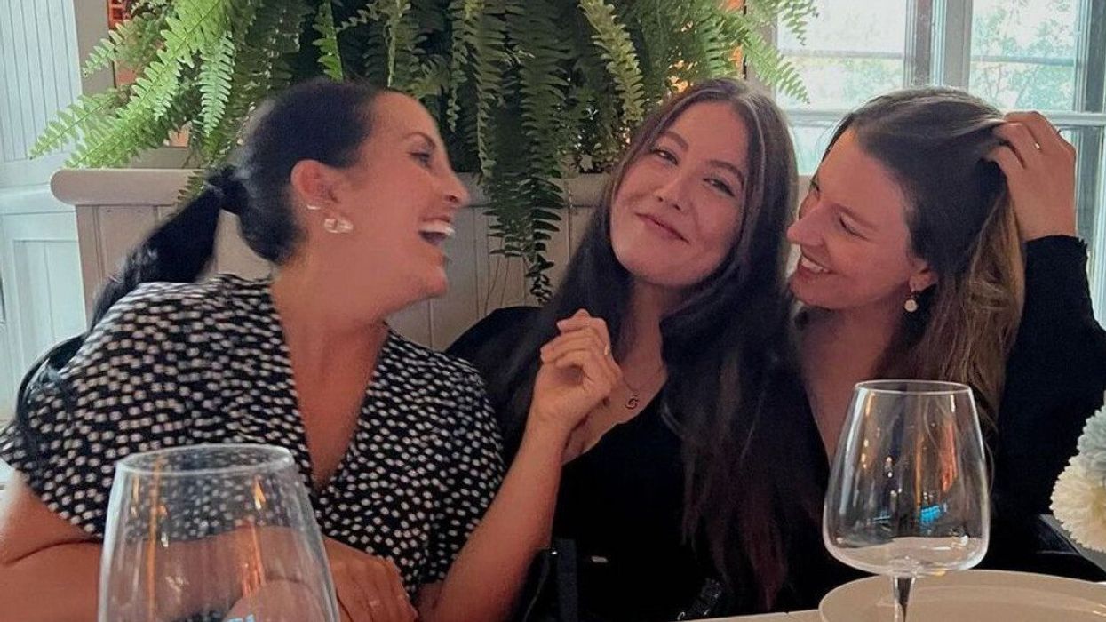 un groupe de trois personnes qui rient au restaurant Pangea devant des verres de vin