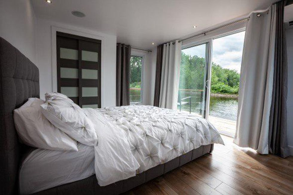 Un lit blanc dans une chambre de la maison flottante \u00e0 louer \u00e0 Qu\u00e9bec.