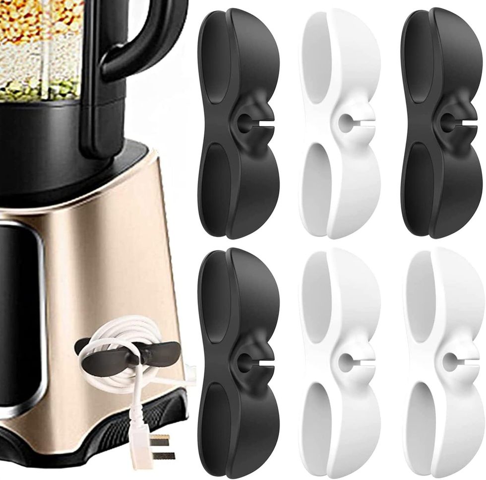 Un malaxeur avec des rangements noirs et blancs de cordons pour appareils \u00e9lectrom\u00e9nagers.